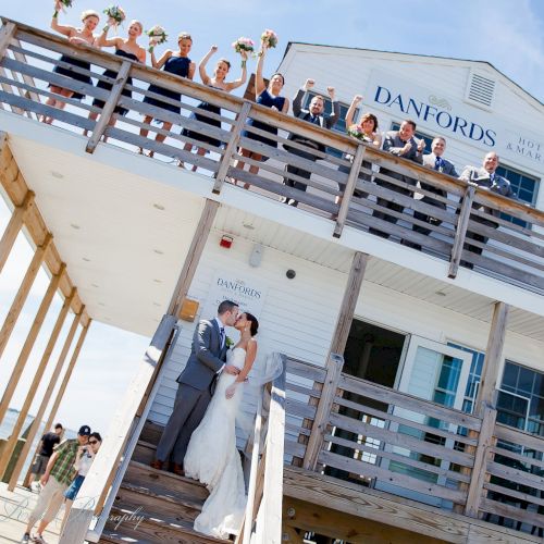 A newlywed couple kisses on stairs outside a building with 